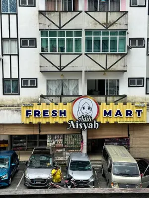 a parking lot with cars parked in front of a building at AYAAN Prima Homestay 1 with Netflix in Tanah Rata