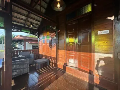 a restaurant with wooden walls and a bench on a porch at Homestay Singgah Keluarga Warisan Abg Tam in Kepala Batas
