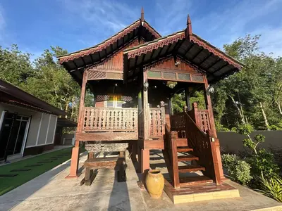 a small wooden gazebo in a yard at Homestay Singgah Keluarga Warisan Abg Tam in Kepala Batas