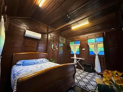 a bedroom with a bed in a room with wooden walls at Homestay Singgah Keluarga Warisan Abg Tam in Kepala Batas