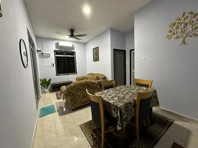 a dining room and living room with a table and chairs at Homestay Singgah Keluarga Warisan Abg Tam in Kepala Batas