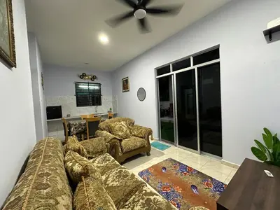 a living room with a couch and a ceiling fan at Homestay Singgah Keluarga Warisan Abg Tam in Kepala Batas