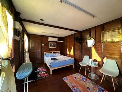 a bedroom with a bed and chairs in it at Homestay Singgah Keluarga Warisan Abg Tam in Kepala Batas