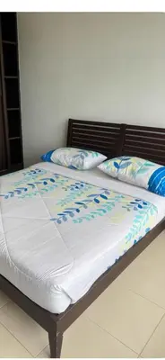 a bed with blue and white sheets and pillows at Deluxe Apartment CintaSayang Resort in Sungai Petani