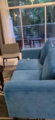 a living room with two blue couches and a chair at Deluxe Apartment CintaSayang Resort in Sungai Petani