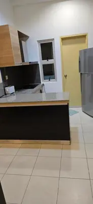 a kitchen with a counter top and a refrigerator at Deluxe Apartment CintaSayang Resort in Sungai Petani