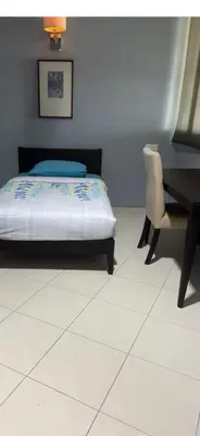 a bedroom with a bed and a desk and a chair at Deluxe Apartment CintaSayang Resort in Sungai Petani