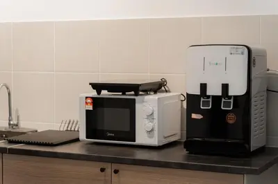 a kitchen counter with a microwave and a coffee maker at VibeHaus Snooker SimpangAmpat ``` 4Room10Pax3Bath in Simpang Ampat