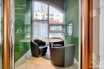 a table and two chairs in a room with a window at 22 Macalisterz's Armoire Collection by ALV in George Town