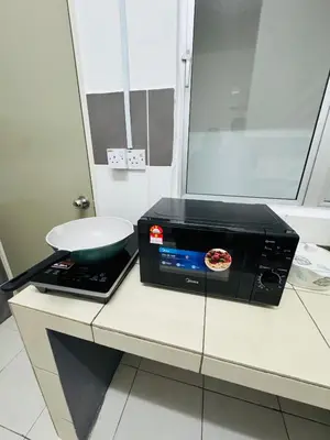 a microwave oven sitting on a counter with a pizza on it at AYAAN Budget Homestay at Tanah Rata in Tanah Rata