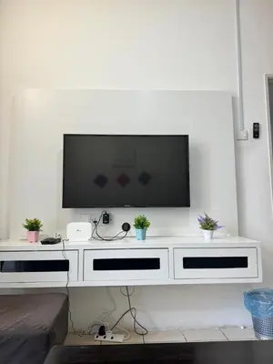 a white entertainment center with a flat screen tv on a wall at AYAAN Budget Homestay at Tanah Rata in Tanah Rata