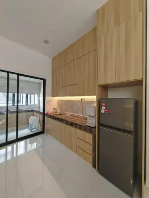 a kitchen with wooden cabinets and a stainless steel refrigerator at Ipoh M Villa 2 in Ipoh
