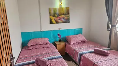 two beds in a room with pink and blue at Rumah Inap Haziq in Seri Manjung