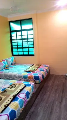 two beds sitting in a room with a window at Fastbook Sun Moon City Home 12Pax in Ayer Itam