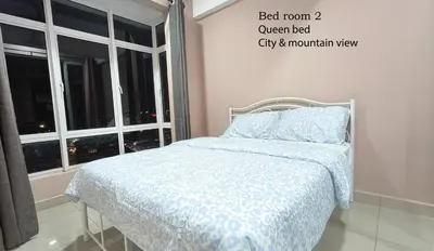 a bed with a blue comforter in a room with a window at H2H - Majestic A19 stay station - 5pax in Ipoh