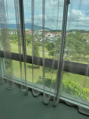 a window with a view of a green field at 2Bedroom Condo at Cinta Sayang Resort in Sungai Petani