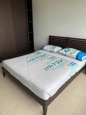 a bed with white sheets and blue pillows on it at Deluxe Apartment at CintaSayang Resort in Sungai Petani
