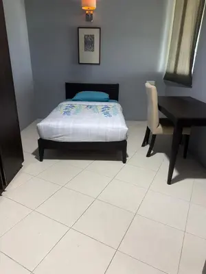 a bedroom with a bed and a table and a desk at Deluxe Apartment at CintaSayang Resort in Sungai Petani