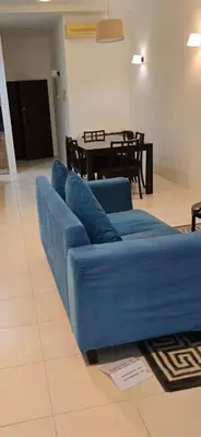 a blue couch in a living room with a table at Deluxe Apartment at CintaSayang Resort in Sungai Petani