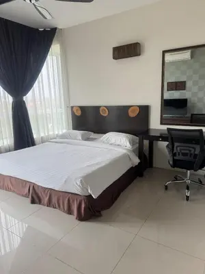 a bedroom with a bed and a desk and a chair at Executive Apartment at Cinta Sayang Club in Sungai Petani