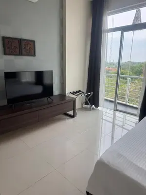 a bedroom with a flat screen tv and a large window at Executive Apartment at Cinta Sayang Club in Sungai Petani