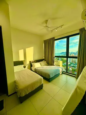 a hotel room with two beds and a large window at urban suites 3 bedroom 10pax a29 in Jelutong