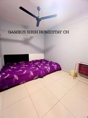a bedroom with a purple bed and a ceiling fan at Gambus Sireh Homestays in Tanah Rata