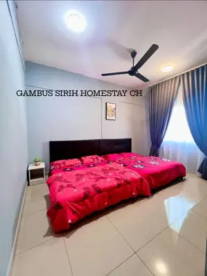 a red bed in a room with a ceiling fan at Gambus Sireh Homestays in Tanah Rata