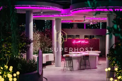 a showroom with a table and chairs and purple lighting at 22 Macalisterz by YourSuperhost in George Town