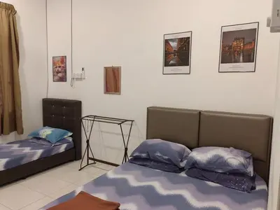 two beds in a room with pictures on the wall at Homestay Rumahku Jana in Kamunting