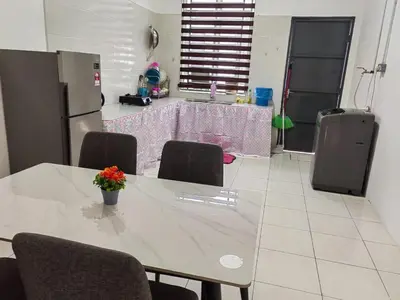 a kitchen with a table with chairs and a refrigerator at Homestay Rumahku Jana in Kamunting