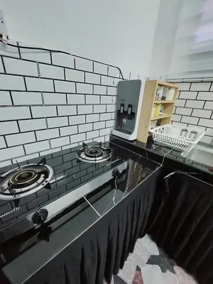 a kitchen counter with a stove and a microwave at Fz North Meru Impian in Ipoh