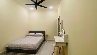a bedroom with a bed and a ceiling fan at Prima Lodge Homestay in Kulim