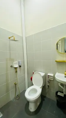 a bathroom with a toilet and a sink at Prima Lodge Homestay in Kulim