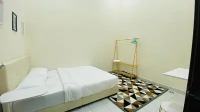 a bedroom with a bed and a tiled floor at Prima Lodge Homestay in Kulim