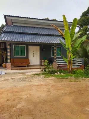 a house with a palm tree in front of it at Teratak Desa Cemerlang 2 in Kuala Kangsar