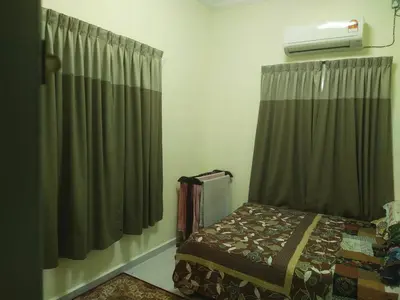 a bedroom with a bed and a window with curtains at Teratak Desa Cemerlang 2 in Kuala Kangsar