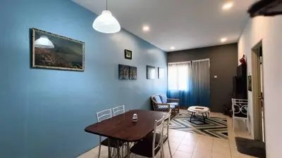 a room with a table and chairs and a blue wall at Budjet Homestay CH in Tanah Rata