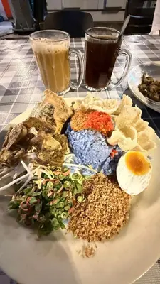a plate of food with an egg and other foods at Budjet Homestay CH in Tanah Rata