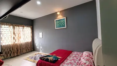 a bedroom with a bed with a red blanket at Budjet Homestay CH in Tanah Rata