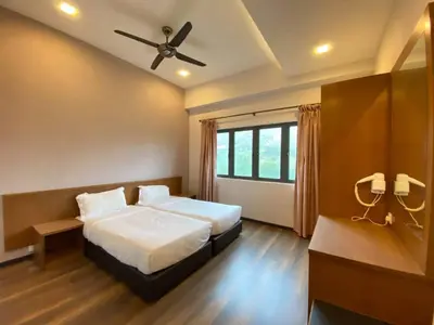 a bedroom with two beds and a ceiling fan at Nova Homestay Cameron Highlands in Brinchang