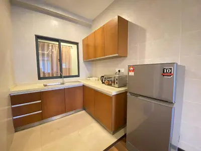 a kitchen with a stainless steel refrigerator and wooden cabinets at Nova Homestay Cameron Highlands in Brinchang