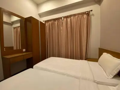 a bedroom with two beds and a mirror and a window at Nova Homestay Cameron Highlands in Brinchang