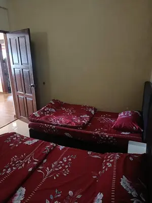 two red beds in a room with a door at Crown Imperial Court - Arsad Homestay Brinchang in Brinchang
