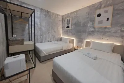 a hotel room with two beds and a mirror at The Cozy Hotel in Sungai Petani