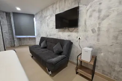 a living room with a couch and a flat screen tv at The Cozy Hotel in Sungai Petani