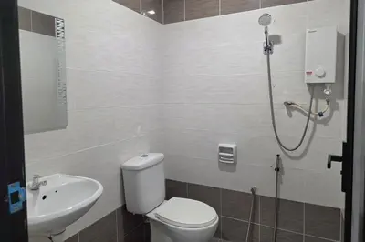 a bathroom with a shower and a toilet and a sink at The Cozy Hotel in Sungai Petani
