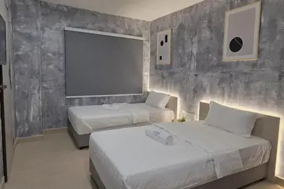 a bedroom with two beds and a large window at The Cozy Hotel in Sungai Petani