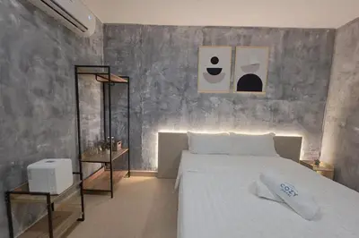 a bedroom with a white bed and a gray wall at The Cozy Hotel in Sungai Petani