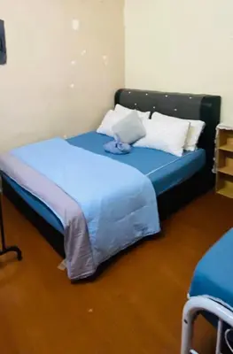 a bedroom with a blue bed with a teddy bear on it at laman terrace stays in Sungai Petani